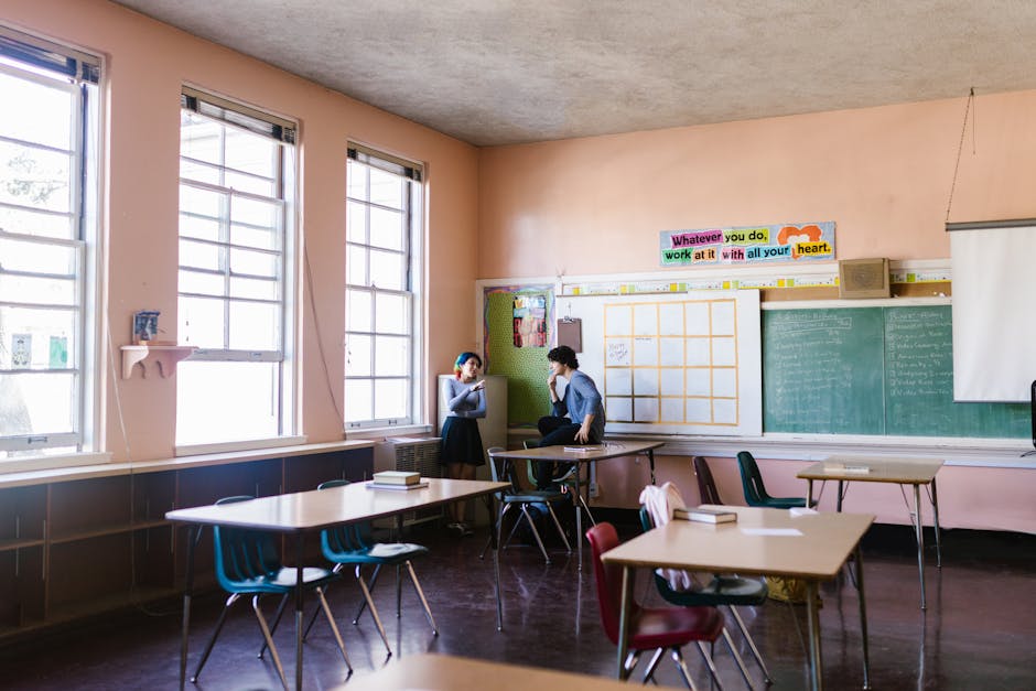 Two students having a conversation in a quiet classroom setting
