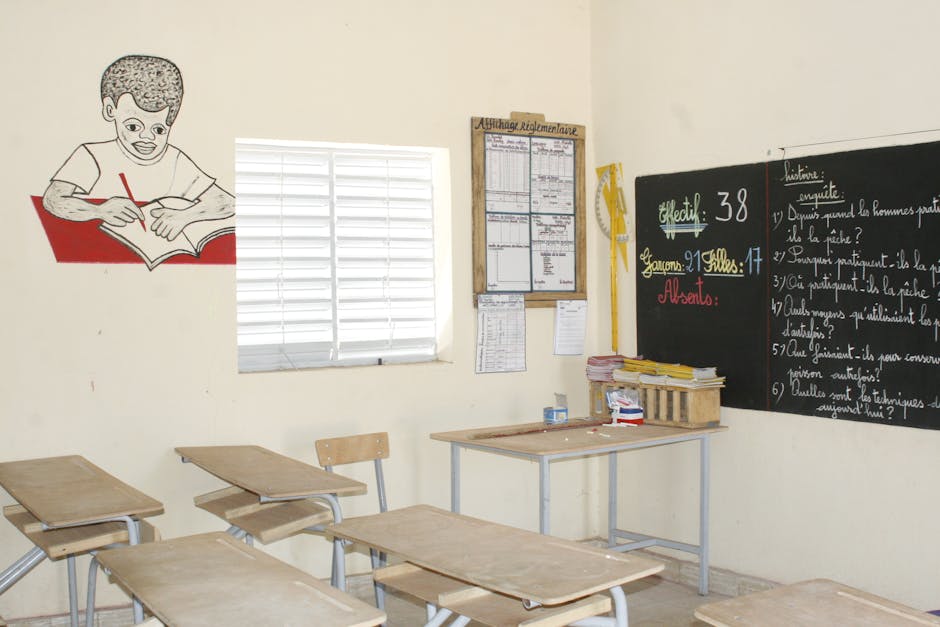 A well-lit classroom with wooden desks, chalkboard, and educational decor